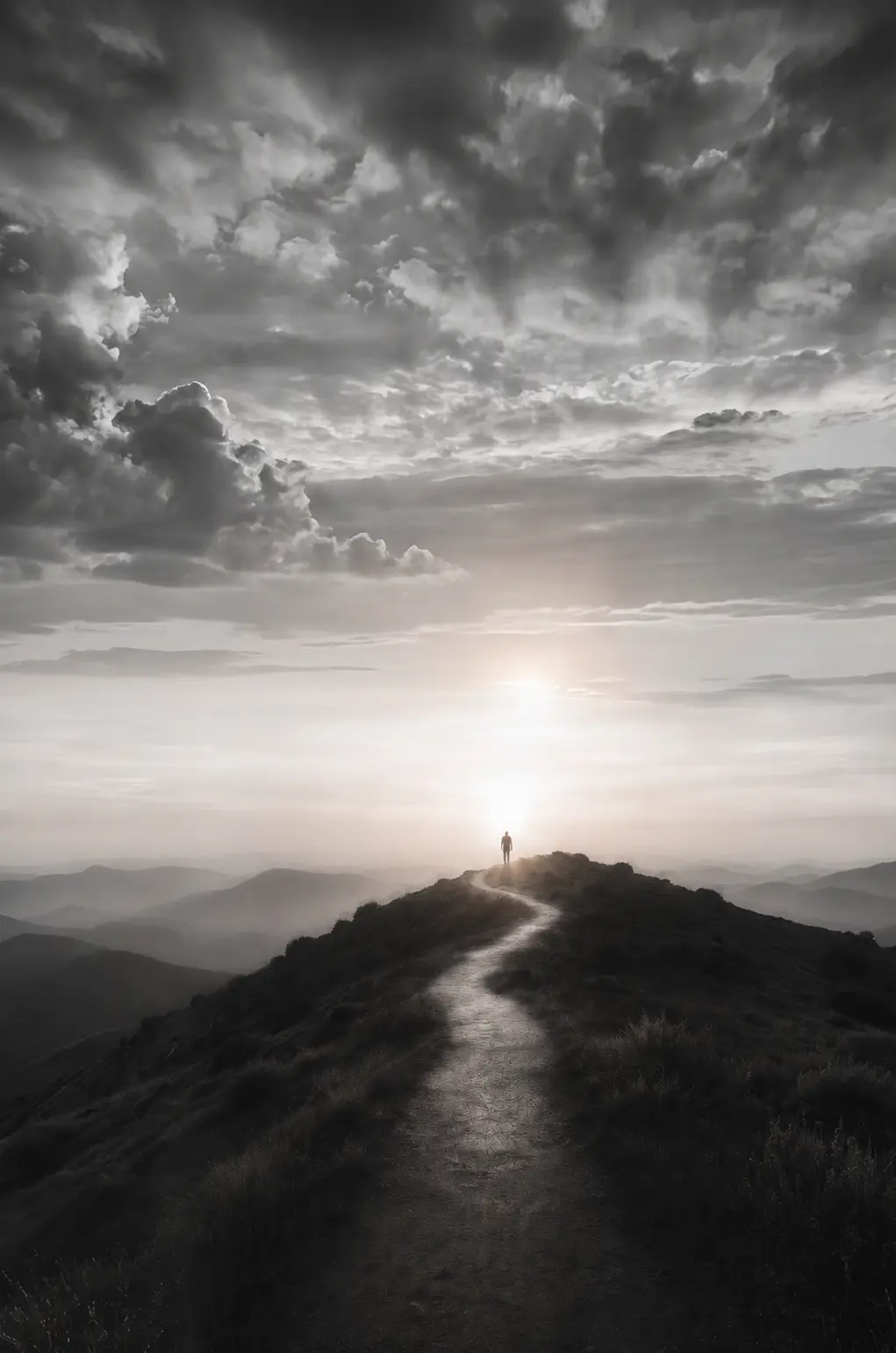 A person following a mountain path towards the light